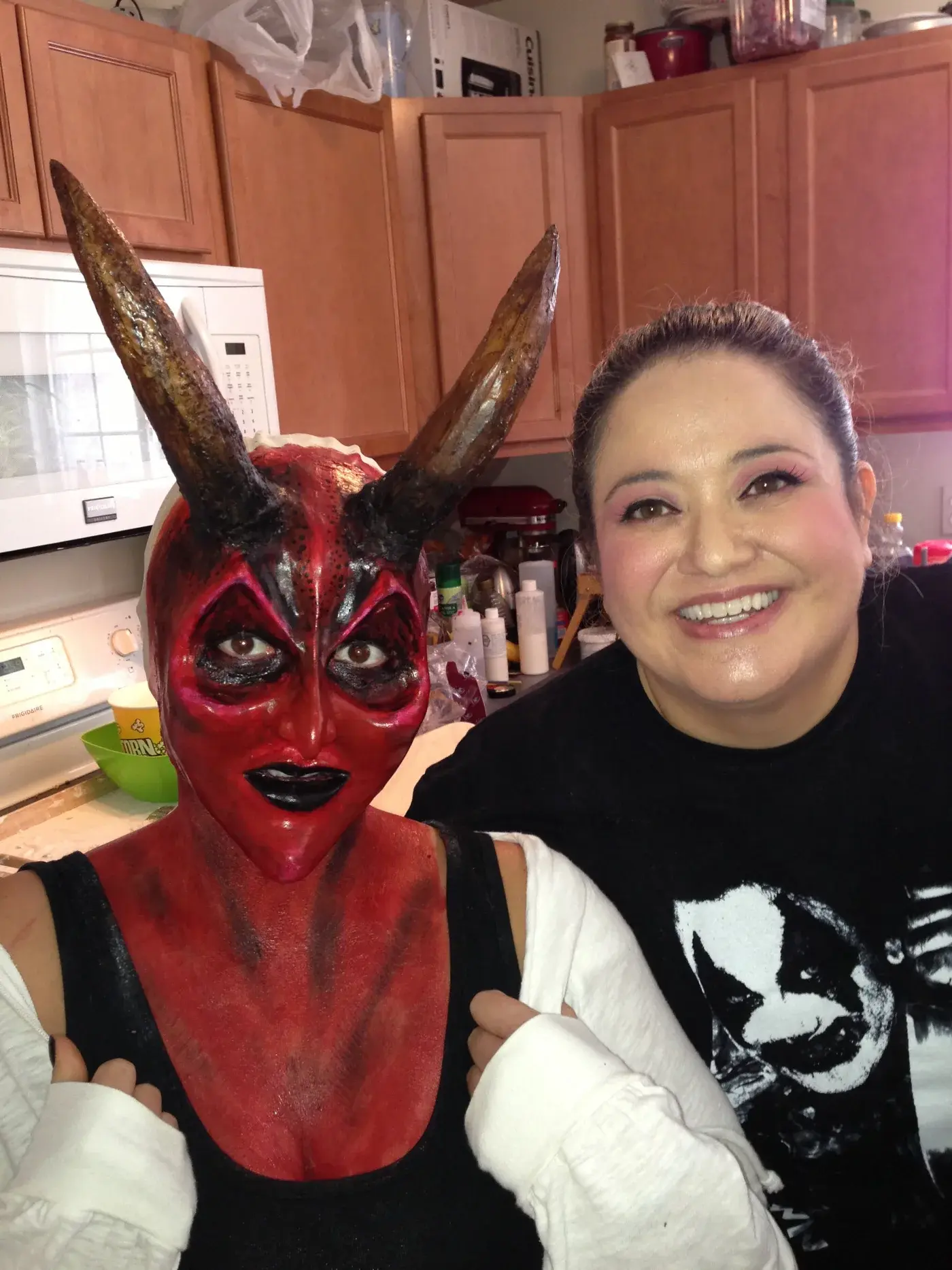 Tommy smiling beside the completed red horned prosthetic makeup