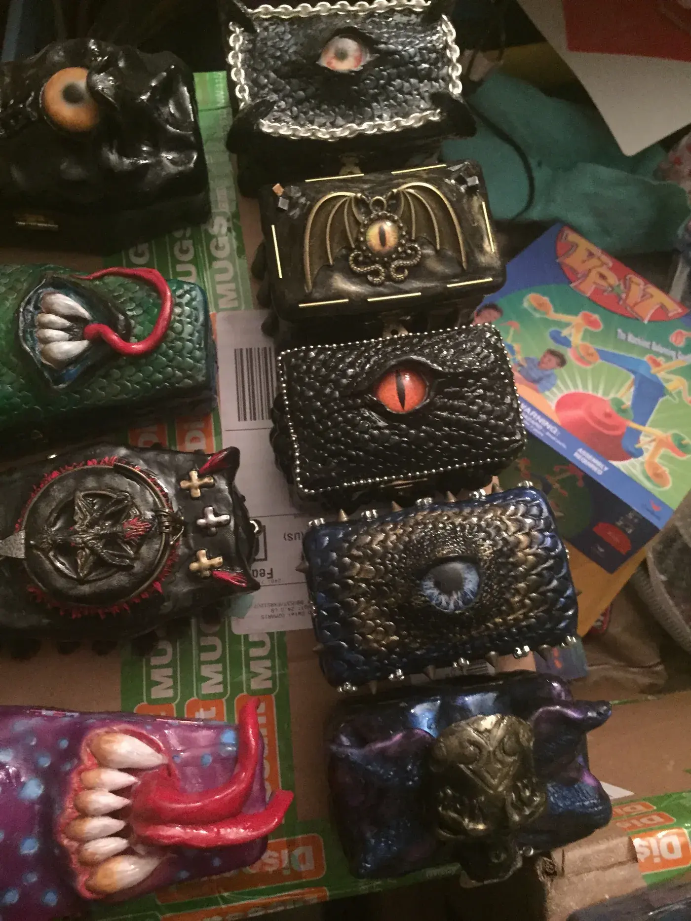 Handmade coffin boxes decorated with sculpted creature eyes, teeth and colorful faces